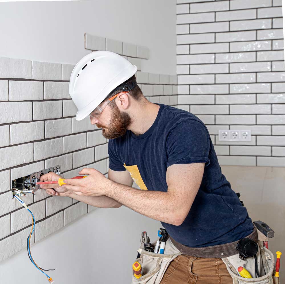 Electricista instalando una llave de luz en la pared